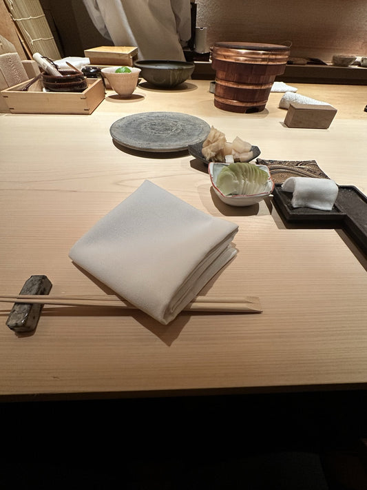 鮨 六式の白木のカウンター。ナプキン、ガリ、銅のたがを巻いたおひつ